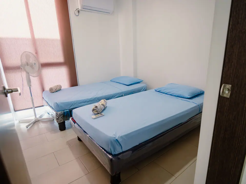 Dormitorio de CASA A12 con dos camas individuales y aire acondicionado.