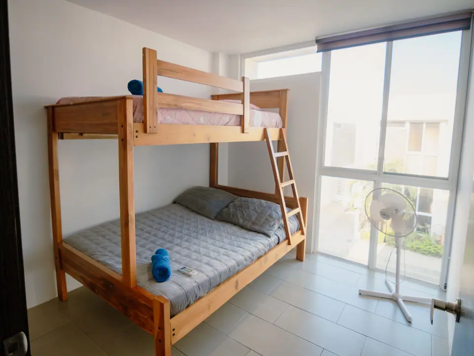 Dormitorio de CASA A12 con una litera de madera: cama doble abajo e individual arriba.