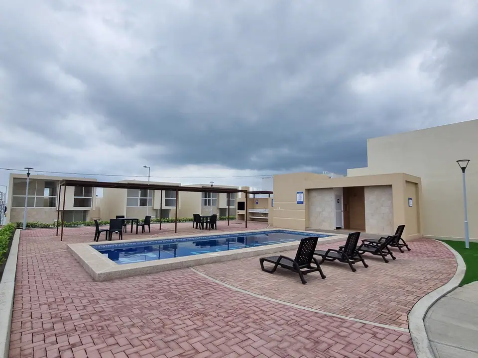 La piscina de la urbanización Punta Arrecife, con tumbonas y mesas a la sombra de una pérgola.