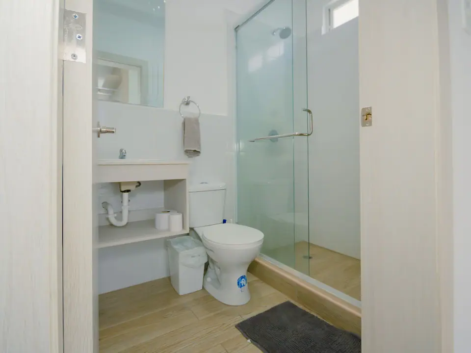 El segundo baño completo de CASA C5, con ducha tras una mampara de vidrio.