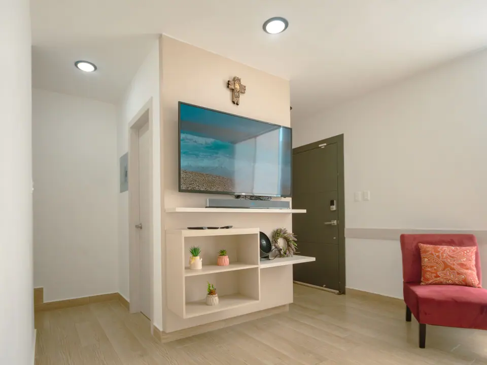 El televisor de CASA C5 en su mueble, junto a la puerta de entrada.